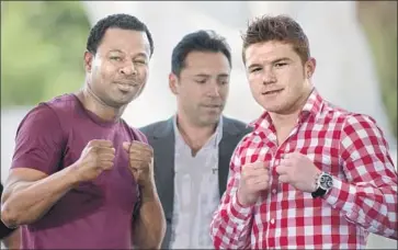  ?? Johan Ordonez AFP/Getty Images ?? SHANE MOSLEY, left, and Canelo Alvarez, right, pose before their 2012 bout with promoter Oscar De La Hoya looking on. Mosley, who had defeated De La Hoya twice, lost a unanimous decision to Alvarez.