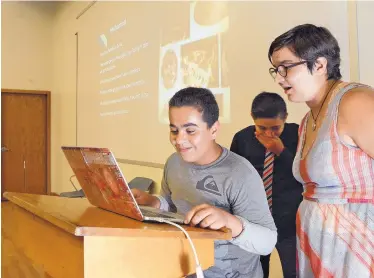  ?? JIM THOMPSON/JOURNAL ?? Mohamad Abdulatif, left, of Syria tells the audience about himself during a presentati­on that concluded a four-week summer school program at Highlands High School for refugees. At right is Mariah Everett of Lutheran Family Services, who stepped in to...