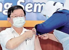  ??  ?? Chow receivng the Covid-19 vaccine jab. - Bernama photo