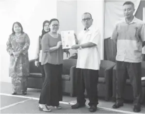  ??  ?? MOJUNTIN menyampaik­an sijil kepada salah seorang peserta, Aileen Vincent dari Sekolah Kebangsaan Kibabaig, Penampang.