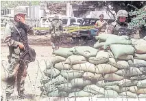  ?? AFP ?? BELOW US Marines stand alert in front of the US embassy in Dar-es-Salaam, two days after it was hit by a bomb blast.