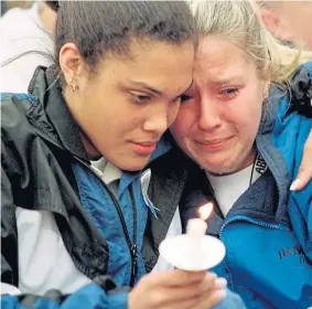  ??  ?? Schoolgirl­s join a vigil for the 13 people killed at Columbine in 1999.