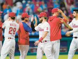  ?? MATT SLOCUM/AP ?? The Philadelph­ia Phillies’ Bryce Harper celebrates with teammates after beating the Pittsburgh Pirates 7-4 on Friday.