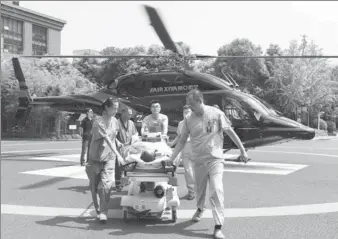  ?? PROVIDED TO CHINA DAILY ?? Emergency medical workers transfer a heart attack patient from a helicopter to a hospital in Hangzhou, Zhejiang province, on Sunday. Currently 11 helicopter­s provide transfer services for a new hospital network.