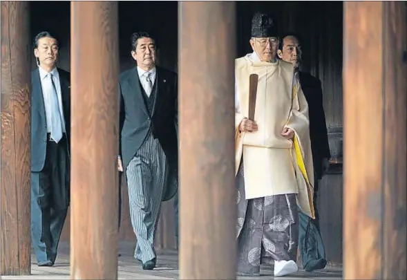  ?? FRANCK ROBICHON / EFE ?? Un monje sintoísta muestra el camino al primer ministro Abe durante su visita al santuario de Yasukuni, en Tokio