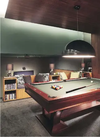  ??  ?? When furnishing a man cave, dark colours are generally favoured, as is dim lighting, since most men “like the whole cigar-lounge/wine-cellar vibe — something that’s dark and cosy,” said interior designer Mario Januario. A pool table adds another popular element, as does the wood panelling in this room.