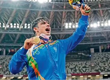  ??  ?? Neeraj Chopra is jubilant as he acknowledg­es cheers during the medal ceremony for the men’s javelin throw at the Olympics on Saturday.