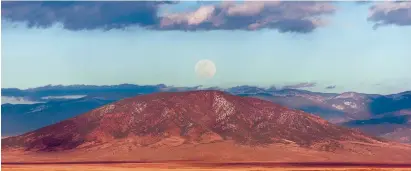  ?? KATHARINE EGLI/THE TAOS NEWS ?? A full moon rises over Ute Mountain, which is located at the northern end of the Rio Grande del Norte National Monument. Secretary of the Interior Ryan Zinke has begun a review of all the U.S. Department of the Interior’s advisory councils, including...