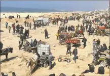  ?? AP photo ?? Palestinia­ns wait for humanitari­an aid on a beachfront in Gaza City, Gaza Strip, on Sunday.