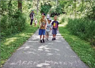  ?? BRIAN KRISTA/BALTIMORE SUN/TNS ?? Fort Meade residents Bryan (from left), 6, Eli Turner, 4, and James Manning, 5, chant pirate phrases as they walk along a path during a Hoco Pirate Adventures treasure hunt in Ellicott City, Maryland, last month.