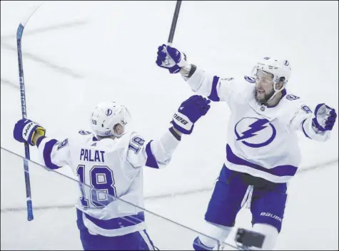  ?? Cole Burston The Associated Press ?? Lightning left wing Ondrej Palat celebrates his second goal of the game with right wing Nikita Kucherov in the second period of Tampa Bay’s 3-1 win over the Bruins on Saturday at Scotiabank Arena.