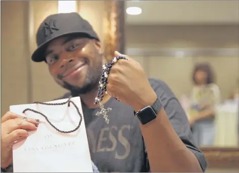  ?? CECILE BOOK PHOTO/DPA GROUP ?? Longtime “Saturday Night Live” cast member and Emmy nominee Kenan Thompson received a necklace made of Asian freshwater pearls, smoky quartz and a sterling silver cross by North Sydney’s Lisa Lee during a gifting suite in Los Angeles in advance of the Emmy Awards.