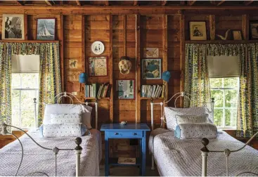  ??  ?? |LEFT| These twin beds are nestled in a nine-bedroom Maine dwelling that was converted from a commercial fishing wharf building into a house in the 1920s. Painted furniture, like this striking blue bedside table, and patterned curtains can be found throughout the home.