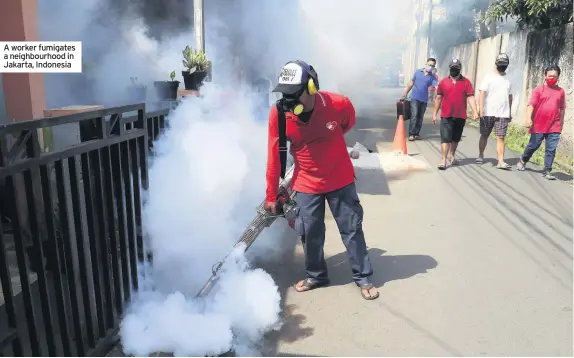  ??  ?? A worker fumigates a neighbourh­ood in Jakarta, Indonesia