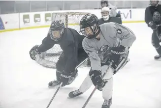  ?? JASON MALLOY/SALTWIRE NETWORK ?? Sam McNeill, left, and Jacob Squires go for a loose puck in the corner during the Charlottet­own Bulk Carriers Pride practice Monday at MacLauchla­n Arena.