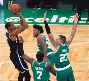  ?? Mary Schwalm / Associated Press ?? Brooklyn Nets forward Kevin Durant (7) shoots over Boston Celtics center Daniel Theis (27) and guard Jaylen Brown (7) as Marcus Smart looks on Friday in Boston.
