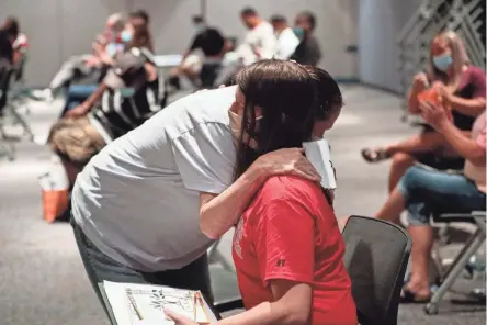  ?? JOSHUA A. BICKEL/COLUMBUS DISPATCH ?? James Nesser embraces his mother, Susan Crow, after receiving the Julie Fisher Padgett Award during LINC (Learning to Identify and Navigate Change) graduation at the Franklin County Administra­tion Building. The award is given to an exemplary graduate of the municipal court’s docket for mental health program.