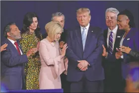  ?? (File Photo/AP/Lynne Sladky, File) ?? Faith leaders pray in January 2020 with President Donald Trump during a rally for evangelica­l supporters at the King Jesus Internatio­nal Ministry church in Miami. On Friday, The Associated Press reported on a manipulate­d version of this photo circulatin­g online depicting the people praying over a golden idol of former President Donald Trump. While numerous attendees of this year’s Conservati­ve Political Action Conference in Orlando, Florida, posed for selfies with a 6-foot-tall golden statue of Trump, the original photo was made over a year earlier.