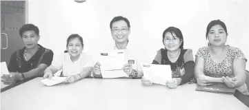  ??  ?? Law (second right) with associatio­n secretary Tan Phuey Hua (right) and other team members show the applicatio­n forms for the microcredi­t under 1Malaysia Hawkers and Small Traders Foundation.