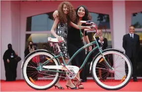  ?? (Max Rossi/Reuters) ?? SAUDI ARABIAN DIRECTOR Haifaa al-Mansour (right) and actress Waad Mohammed pose with a bicycle on the red carpet during the premiere screening of ‘Wadjda’ during the 69th Venice Film Festival in 2012.