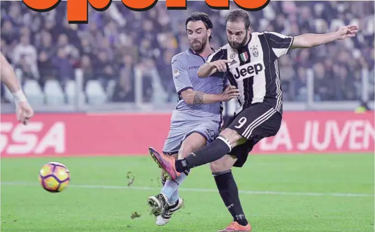  ??  ?? TURIN: Juventus’ Gonzalo Higuain, right, kicks the ball past Sampdoria’s Luca Cigarini during a Serie A soccer match between Juventus and Sampdoria at the Juventus stadium. —AFP