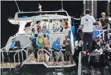  ?? THAILAND ROYAL POLICE VIA AP ?? Rescued tourists from a boat that sank are helped onto a pier on the island of Phuket, southern Thailand.