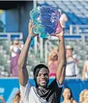  ?? JOHN MCCALL/SUN SENTINEL FILE ?? Frances Tiafoe hoists the trophy after defeating Peter Gojowczyk to win the 2018 Delray Beach Open. Tiafoe was the first wild-card entry to win the tournament.