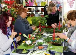  ?? (Photo C. S.) ?? Si pour Christine, la Revestoise, (à gauche) et Anne, la création composée de sapinette, lys de couleur, tulipe, amaryllis sur un joli contenant de cuivre, sera sur leur table, celle d’Arlette partira avec elle en Corrèze et à Barcelone pour Michèle. Laurence Dalmas (debout) a supervisé leur travail.