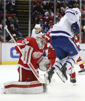  ?? PAUL SANCYA/THE ASSOCIATED PRESS ?? Matt Martin jumps while screening Detroit’s Petr Mrazek, who has allowed four goals in five of his last 10 games.