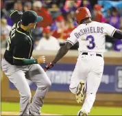  ?? LM OTERO — ASSOCIATED PRESS ?? Delino DeShields of the Rangers reaches first base as an infield throw gets past A’s first baseman Ryon Healy.