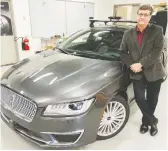  ?? WAYNE CUDDINGTON ?? Grant Courville of QNX stands next to an autonomous test vehicle in Ottawa.