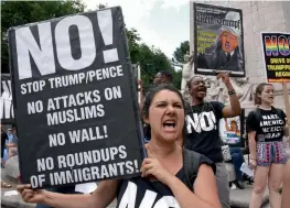  ?? — AFP ?? Protesters with ‘Today Refuse Fascism’ hoist signs at Columbus Circle in New York City on Monday prior to a march to Trump Tower to denounce the Supreme Court’s partial reinstatem­ent of the travel ban on citizens of six Muslim countries.