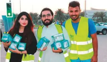  ??  ?? Ayesha and her friends prepare to give iftar packets to the needy outside a hospital in Muharraq in Bahrain. Ramadan is a time to be generous, volunteers say.