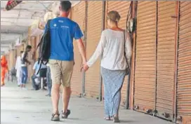  ?? HIMANSHU VYAS/HT PHOTO ?? Tourists stroll past shut shops at Tripoliya in Jaipur, during the nation wide bandh to protest against implementa­tion GST, on Friday.