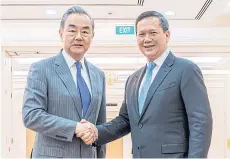  ?? AFP ?? Cambodia’s Prime Minister Hun Manet, right, shakes hands with China’s Foreign Minister Wang Yi during a meeting at the Peace Palace in Phnom Penh on Monday.