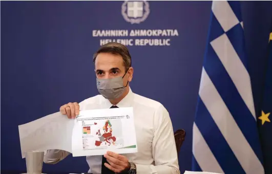  ?? Photo: AP ?? The Greek Prime Minister's Office, Greece's Prime Minister Kyriakos Mitsotakis shows a map of Europe during his announceme­nt on the country's new lockdown in Athens, yesterday. Mitsotakis has announced a nationwide three-week lockdown starting Saturday morning, saying that the increase in the coronaviru­s infections must be stopped before Greece's health care system comes under "unbearable" pressure.