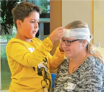  ?? Foto: Michael Ermark ?? Dieser Junge legt beim Erste Hilfe Kurs für Kinder einen Kopfverban­d an.