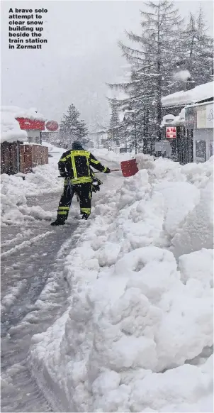  ?? Pictures: MARK RALSTON/AFP ?? A brave solo attempt to clear snow building up beside the train station in Zermatt