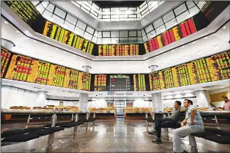  ??  ?? Investors watch trading boards at a private stock market gallery in Kuala Lumpur, Malaysia on May 14. New Malaysian Prime Minister Mahathir Mohamad said a special five-member council would be set up to advise the government on economic and financial...