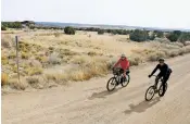  ?? LUIS SÁNCHEZ SATURNO/THE NEW MEXICAN FILE PHOTO ?? Preston Miller, left, and his friend Tim Burns, both of Santa Fe, start a bike ride last month in the Galisteo Basin Preserve.