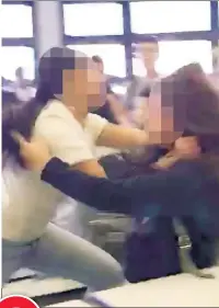  ??  ?? 2 A 14-year-old girl (left) grabs her victim, v a 13-year-old student, by the hhair after taunting, “Let’s start, bro!”