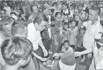  ??  ?? Phoong speaking to Norbayan, who wanted the government to implement the rent-to-own scheme in Sandakan.