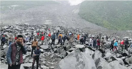  ?? — GETTY IMAGES ?? Emergency personnel and local residents work at the site of a massive landslide in a village in southwest China. Huge rocks and a mass of earth crashed into people’s homes Saturday.