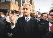  ?? Remko De Waal / AFP / Getty Images ?? Dutch populist leader Geert Wilders distribute­s self-defense sprays in the town of Spijkeniss­e.