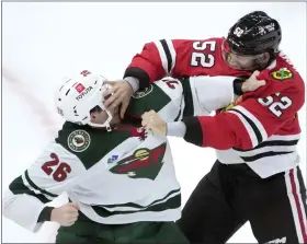  ?? AP PHOTO/CHARLES REX ARBOGAST ?? Chicago Blackhawks center Reese Johnson, right, and Minnesota Wild center Connor Dewar fight during the second period of an NHL preseason hockey game Thursday, Oct. 5, 2023, in Chicago.