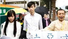  ??  ?? Leung (centre) and Yau (left) from localist political group Youngspira­tion walk with supporters as they leave a court in Hong Kong. — AFP photo