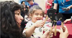  ??  ?? Cross-cultural celebratio­n: A girl playing with a puppet dog during the ‘Lunar New Year Festival: Year of the Dog’ workshop at the Metropolit­an Museum of Art in New York.