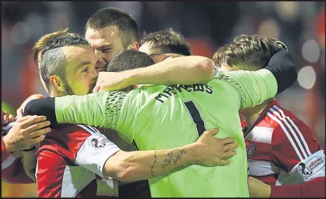  ??  ?? Keeper the home fires burning... Remi Matthews is mobbed by tea-mates after he saved home boss Martin Canning’s blushes in the shoot-out