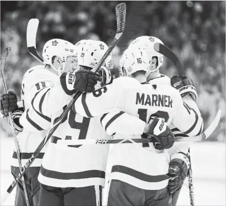  ?? CHRIS O'MEARA THE ASSOCIATED PRESS ?? Toronto Maple Leafs centre Mitchell Marner celebrates with teammates after scoring against the Tampa Bay Lightning during the first period of a National Hockey League game Monday night in Tampa, Fla. For complete game coverage and more NHL news, see niagarafal­lsreview.ca.