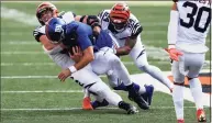  ?? Aaron Doster / Associated Press ?? Cincinnati Bengals defensive end Sam Hubbard, left, tackles New York Giants quarterbac­k Daniel Jones, middle, as Cincinnati Bengals strong safety Vonn Bell, defends on Sunday.